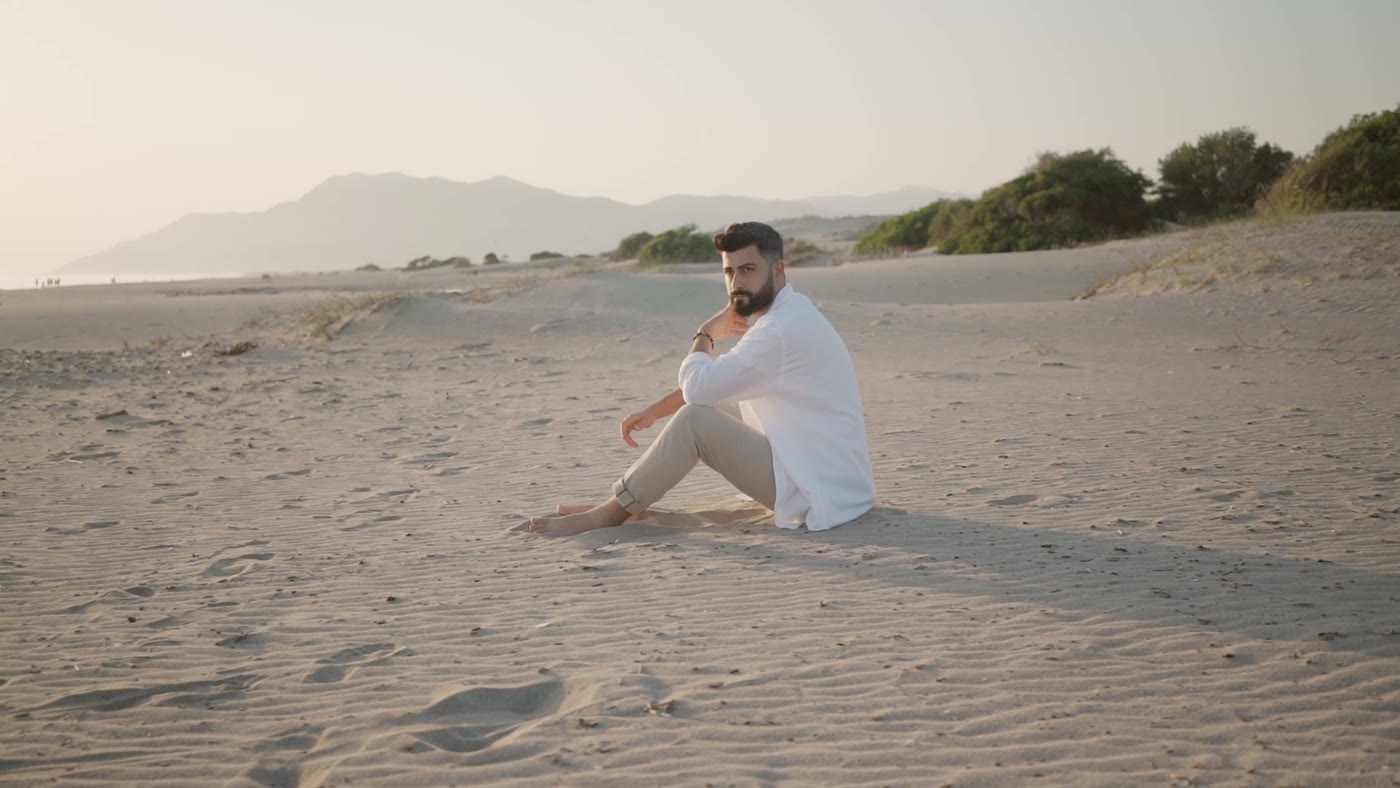 A man taking a quiet moment on a sunlit beach